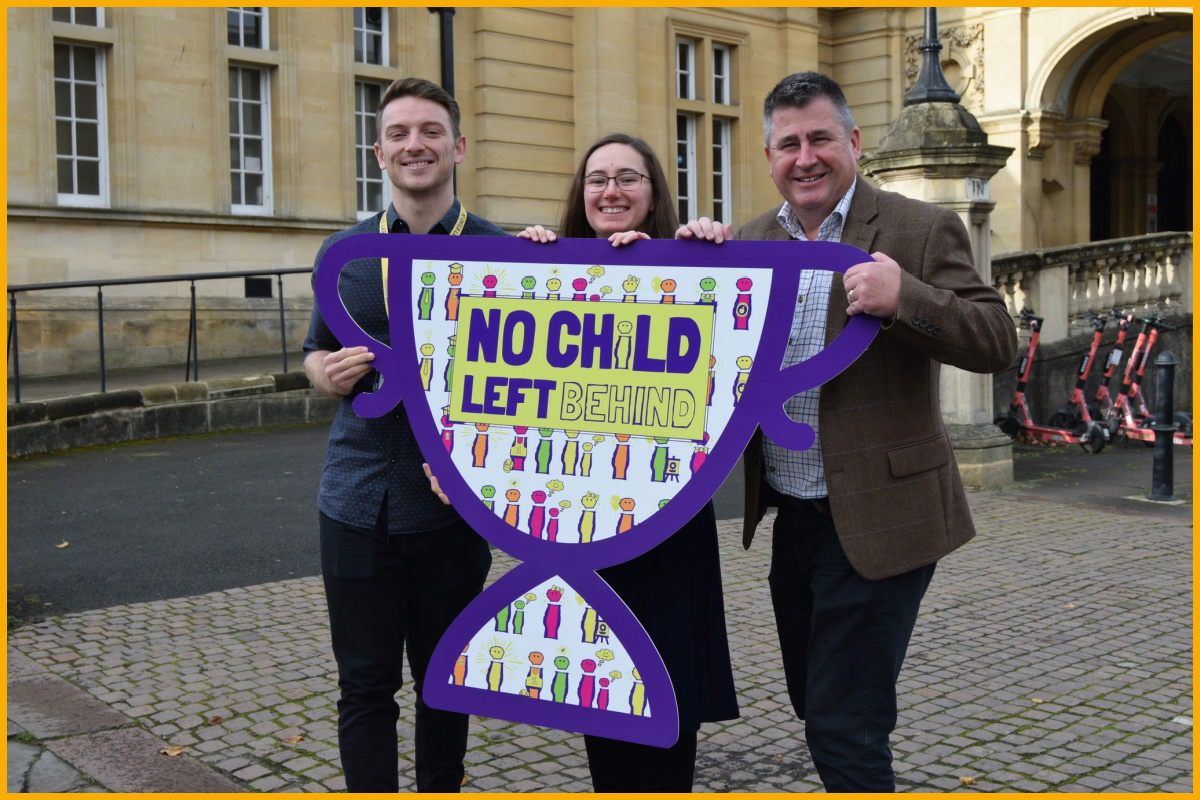 No Child Left Behind team holding a No Child Left Behind sign.